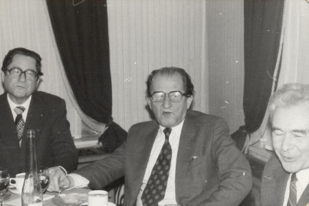 Jerzy Wojtowicz (pierwszy z lewej) w czasie uroczystości wręczenie księgi pamiątkowej prof. Andrzejowi Tomczakowi, w centrum kadru Marian Wojciechowski (Naczelny Dyrektor Archiwów Pańtwowych) i jubilat; Toruń, 13.11.1984 (Fotoronika IHiA) 